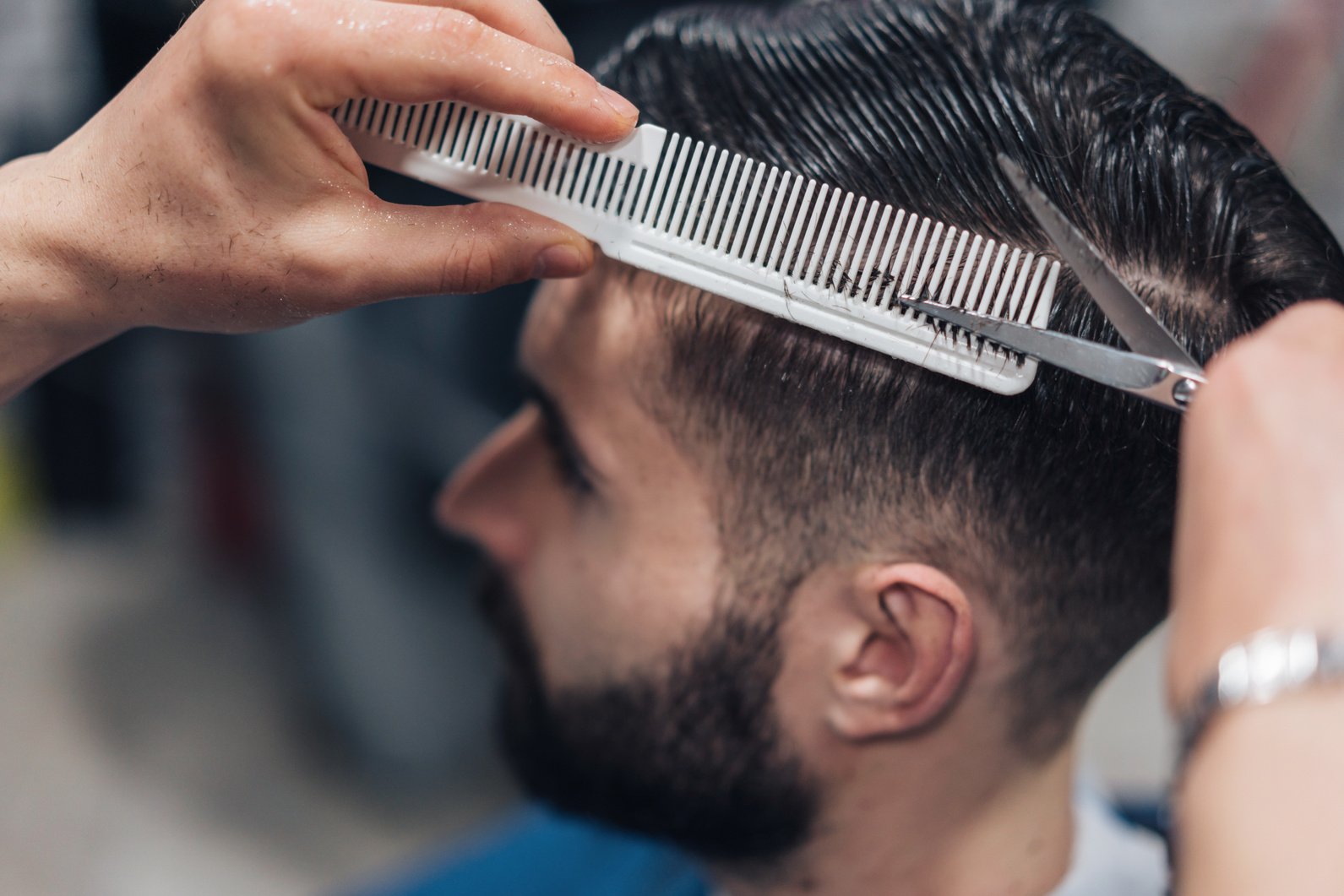 Young man getting stylish haircut